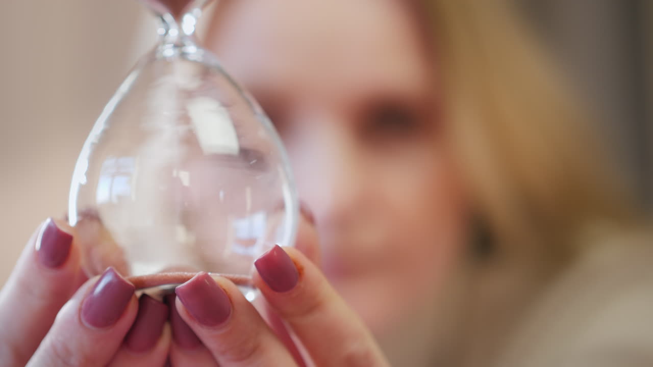 retrato de una mujer con un reloj de arena en las manos
