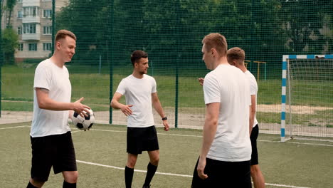 group of young soccer players greeting each other on a street football pitch