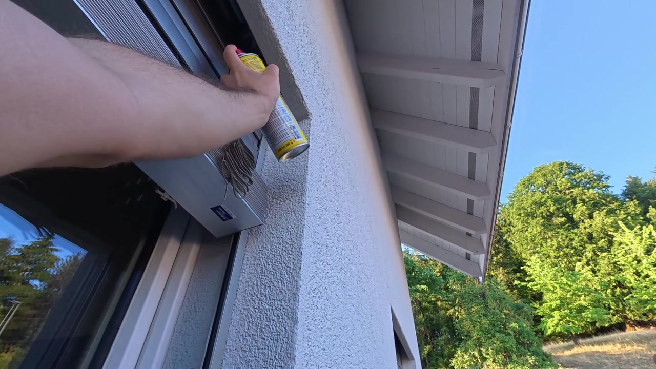 Eerstepersoonsperspectief van het spuiten van insectenwerend middel rond een raamkozijn. Ideaal voor concepten rond ongediertebestrijding, huisbeheer, insectenpreventie en huishoudelijke bescherming