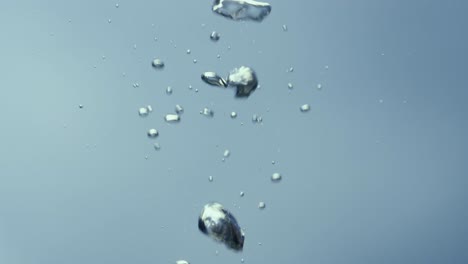 shiny Air Bubbles Rising up in the Water Column Shiny Air Bubbles Rising up in the Water Column of the Reservoir Freshness of a Clear Blue Liquid Poured into Container Transparent Blue Aqua with Light Glare Close up Filming of Liquid through the Glass of an Aquarium or Tank