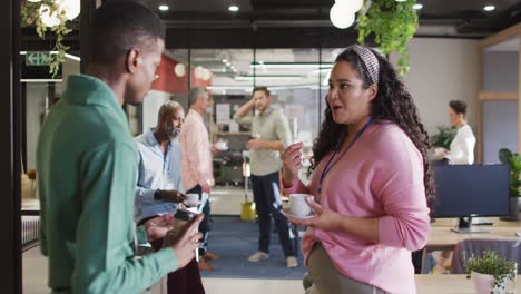 Happy-diverse-business-people-discussing-work-during-meeting-at-office