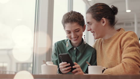 young people using smartphone in cafe