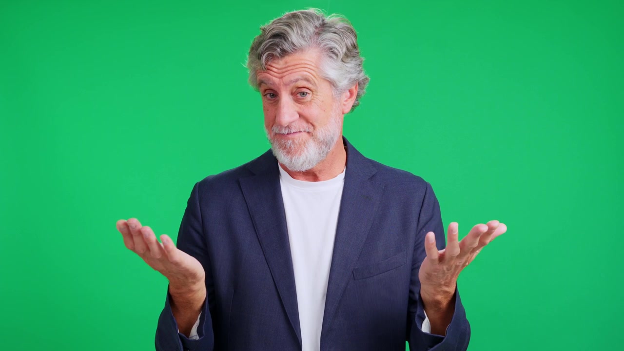 Mature businessman making money gesture on green screen