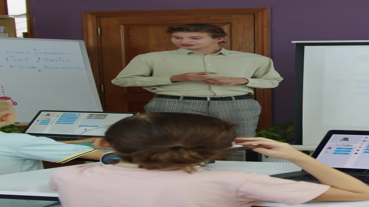 Teacher Explaining Topic to Group of Kids at IT Class