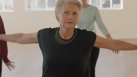 yoga-class-beautiful-elderly-woman-exercising-healthy-lifestyle-practicing-warrior-pose-enjoying-group-fitness-workout-in-studio