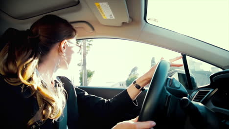 Business-woman-driving-while-talking-on-the-phone,-smiling-and-laughing