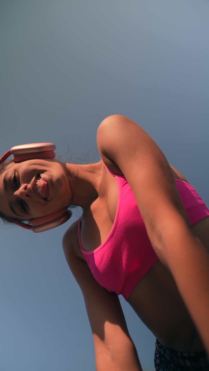 una adolescente con auriculares y sostén deportivo