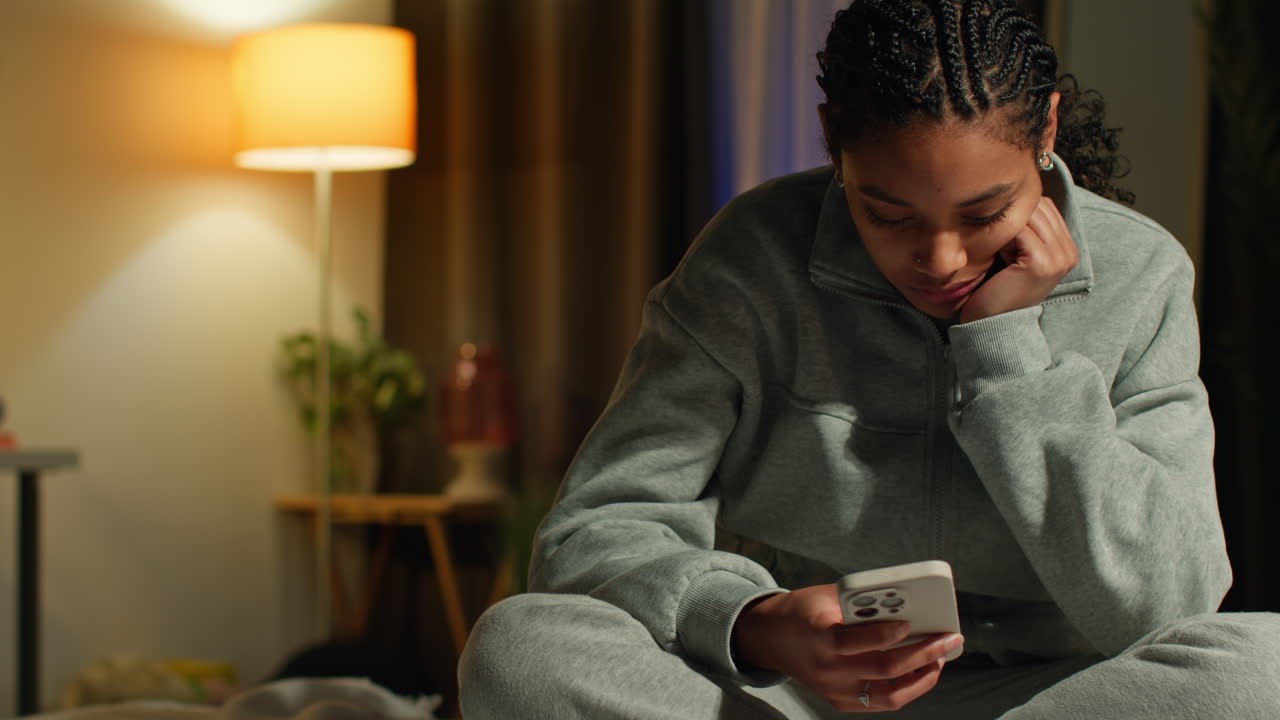 Teenager looking at phone in bedroom at night