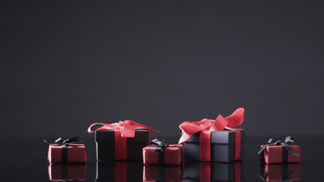 video de cajas de regalos con cintas rojas y negras y espacio de copia sobre fondo negro