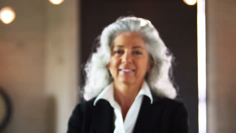 smiling middle aged businesswoman walking into focus
