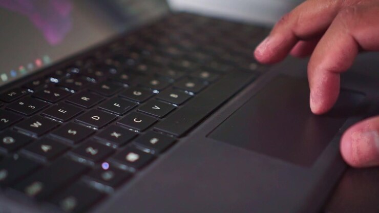 Finger wischt auf Laptop-Trackpad, moderne Technologie, Online-Browsing, Detailaufnahme, Benutzerinteraktion.