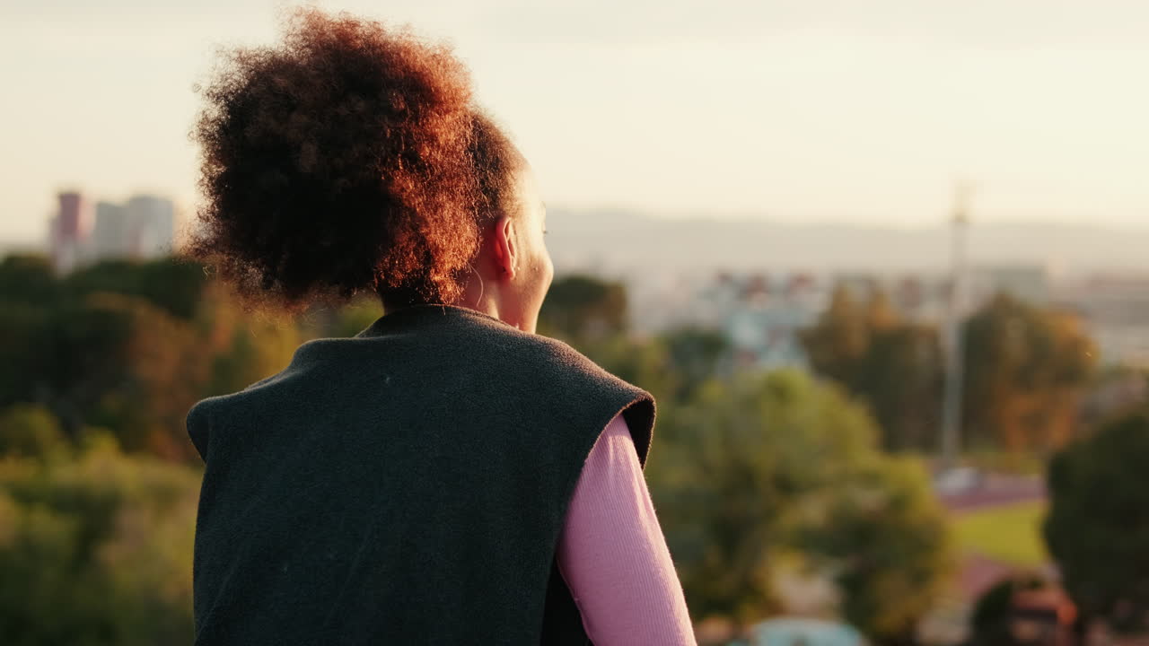 Woman Enjoys Sunset Over City Landscape