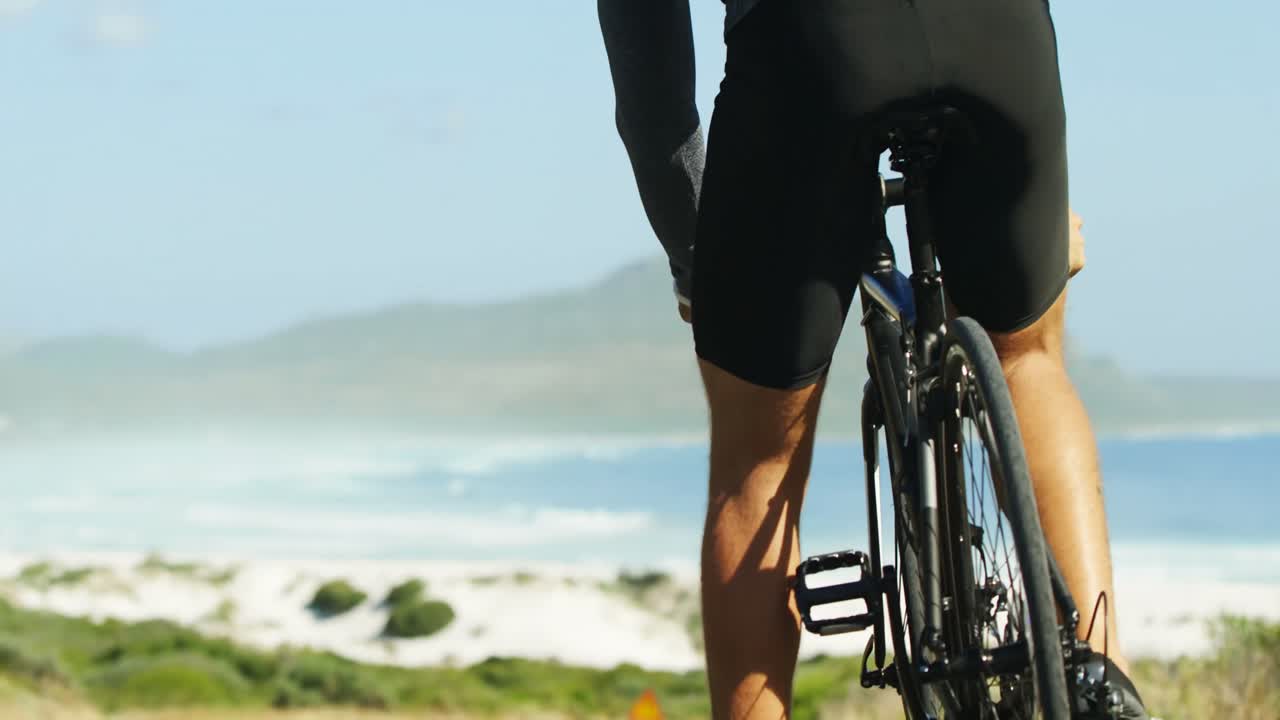 트라이애슬레트 선수 가 자전거 를 타기 위해 준비 하고 있는 뒤쪽 의 모습