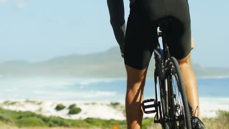 Rear-view-of-triathlete-man-getting-ready-to-ride-a-cycle