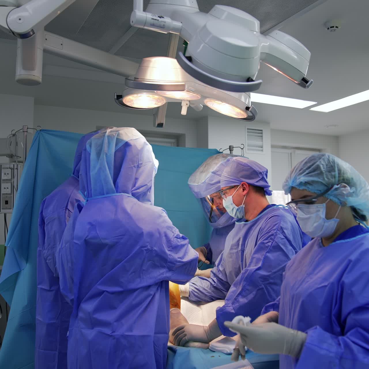 Surgical specialists team conducting the surgery on a knee joint. Medical group collaborating at endoprosthetic operation in modern hospital