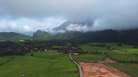 bird's-eye view advancing over a valley in laos, showcasing its beautiful green mountains and vast rice plantations