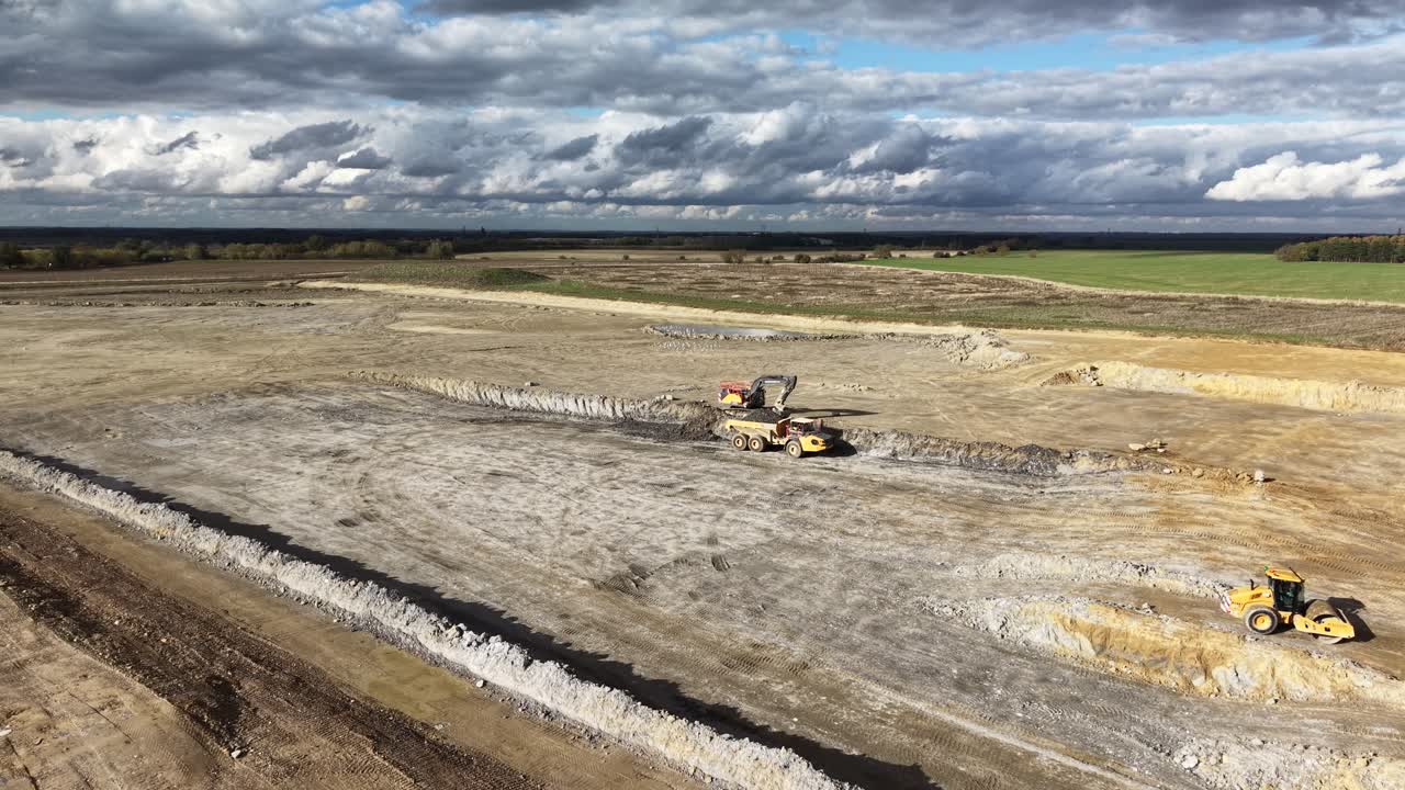 Excavator clearing earth for new A428 highway road upgrade Cambridgeshire UK aerial