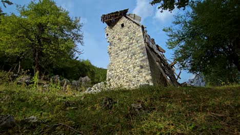 abandoned mountain village in albanian alps: ruined stone houses and tower, reflecting emigration and the changing landscape