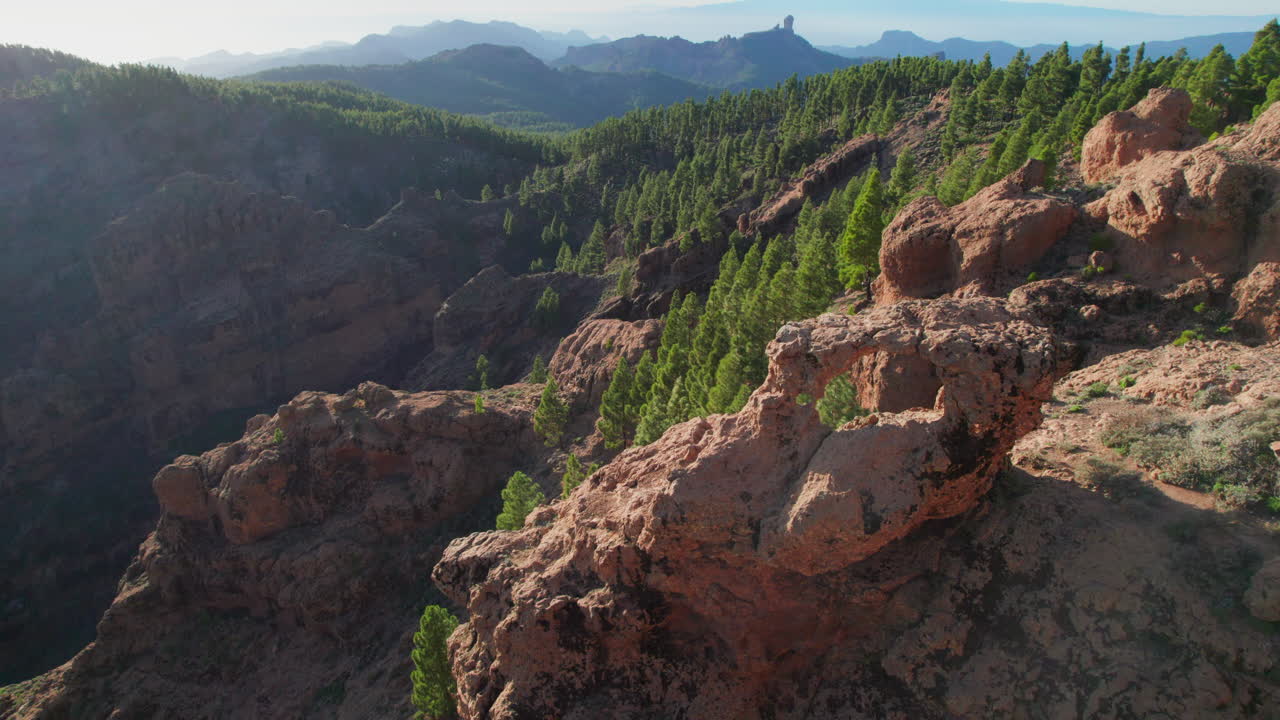volando sobre la ventana del roque nublo en la isla de gran canaria y el volcán teide en el fondo