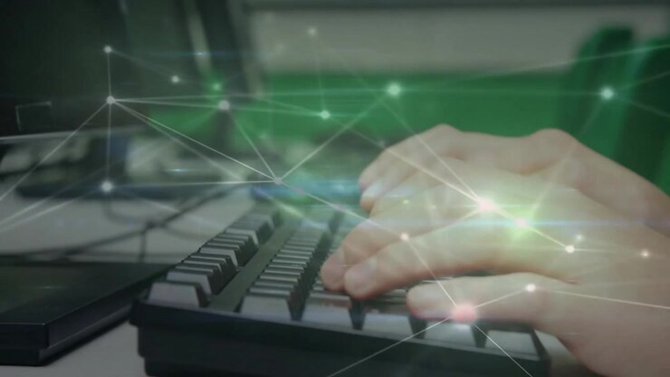 Asian male leaning and typing on keyboard while network overlay pulsing and visualizing data