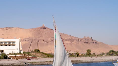 Detalle-De-Un-Foque-Faluca-Con-Una-Colina-De-Arena-En-El-Fondo,-Asuán,-Egipto