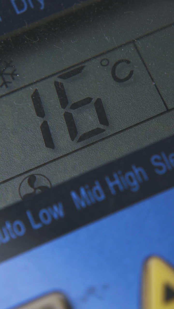 man switches on air conditioner and changes temperature mode with remote control extreme close view