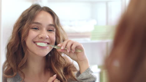 mujer sonriente cepillándose los dientes espejo delantero en el baño. higiene dental y oral