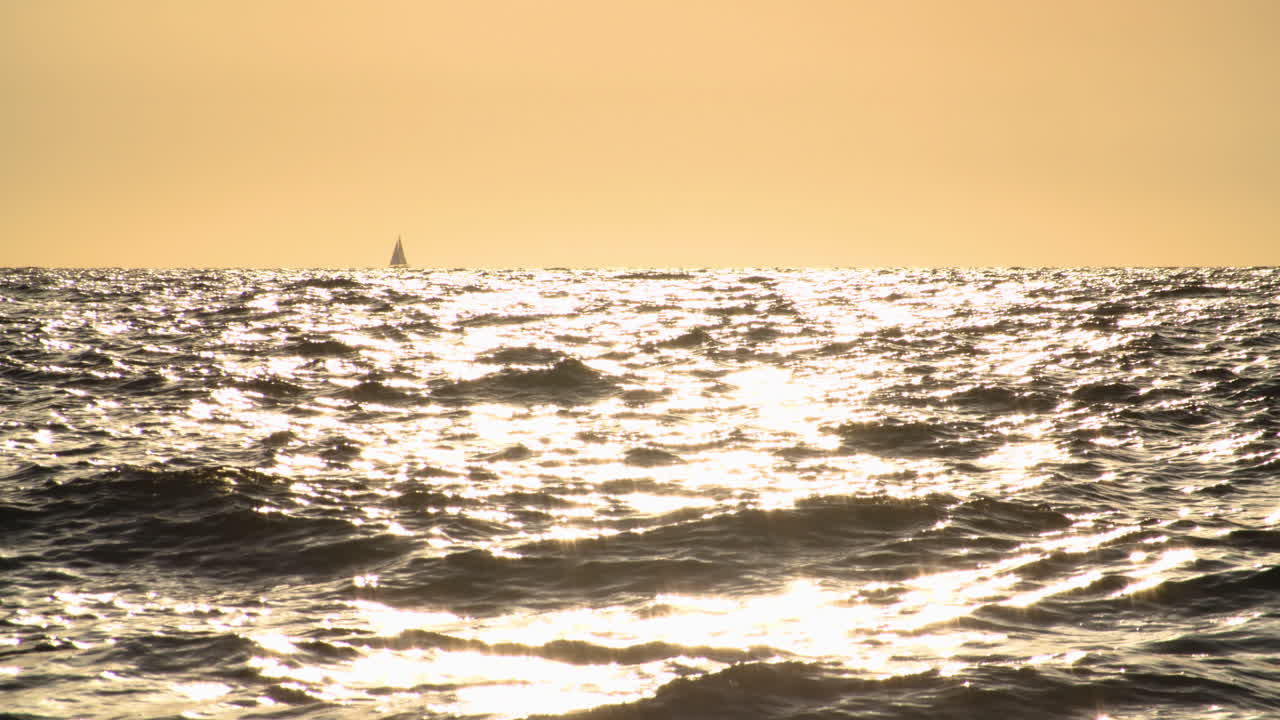 Sailboat on Calm Ocean at Sunset