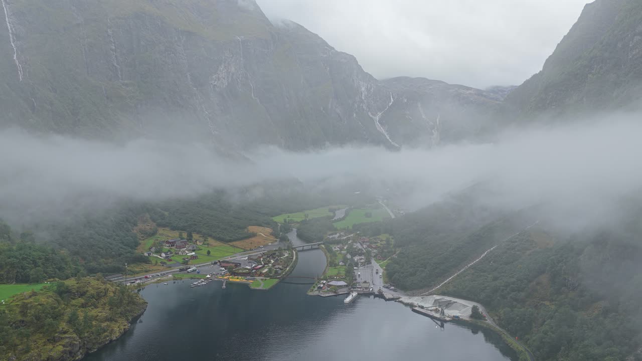 Letecký pohled na vesnici Gudvangen v dramatickém mlhavém údolí v Norsku.