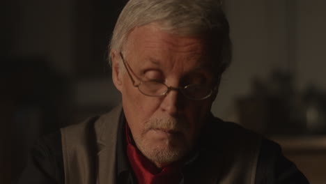 old passionate man put on the glasses in his office at night