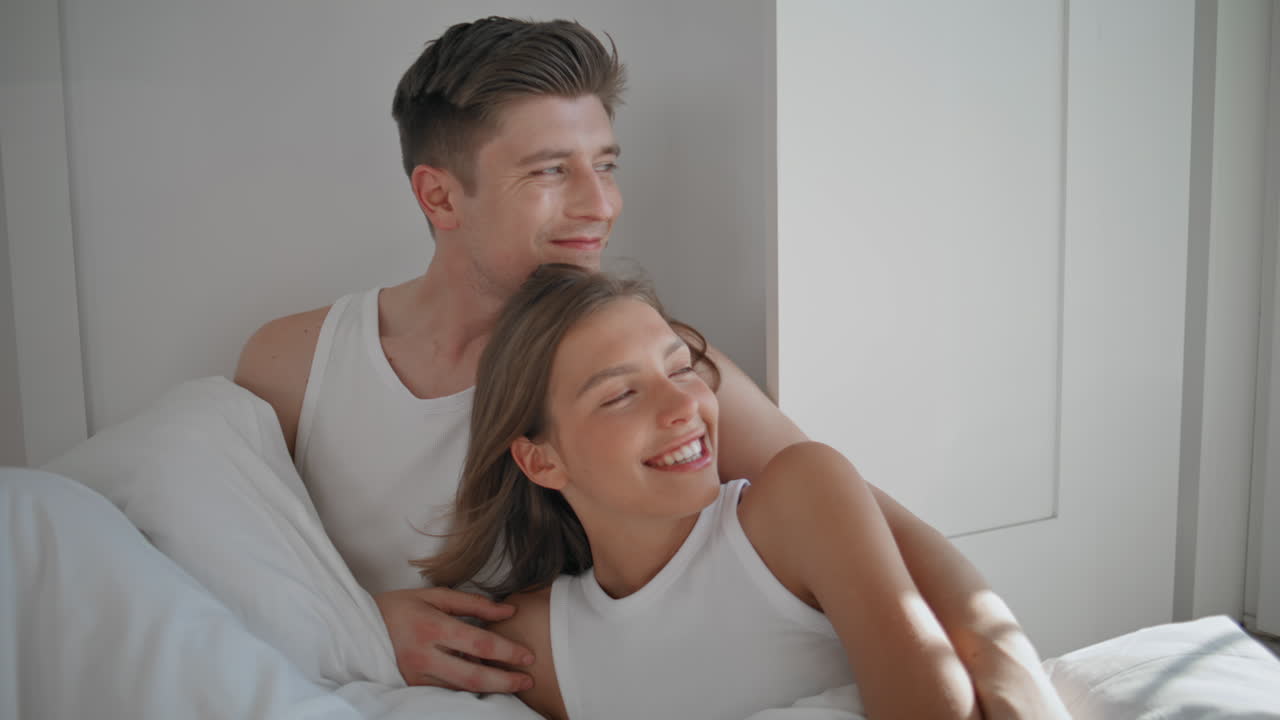 Affectionate lovers relaxing home together closeup. Cheerful couple cuddling