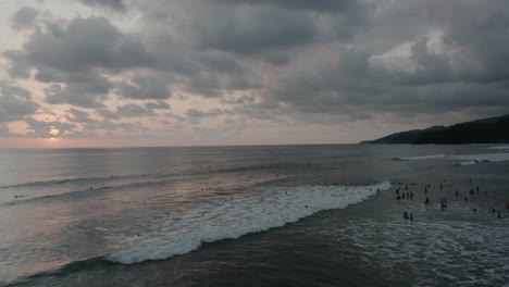 Toma-Aérea-De-Drones-Panorámica-Que-Revela-Montañas-Y-La-Gente-En-La-Playa-En-4k,-Costa-Rica