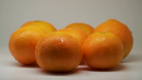 siete naranjas carnosas con gotitas de agua encima de la mesa - primer plano
