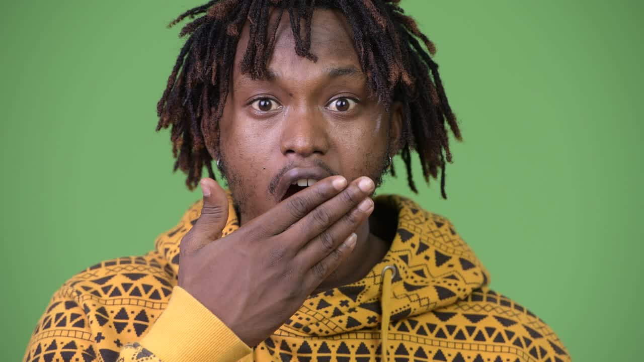 Young handsome African man looking shocked