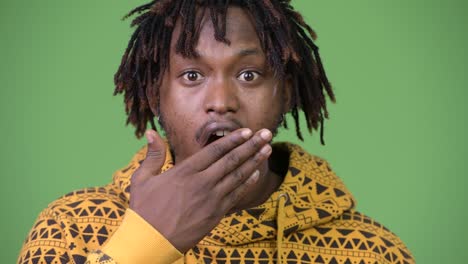 young handsome african man looking shocked