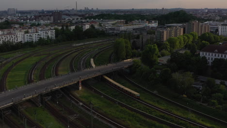 Verfolgung-Der-S-Bahn-Zugeinheit,-Die-Auf-Gleisen-In-Den-Bahnhof-Einbiegt.-Stadtszene-Von-Der-Späten-Abendsonne-Beleuchtet.-Berlin,-Deutschland