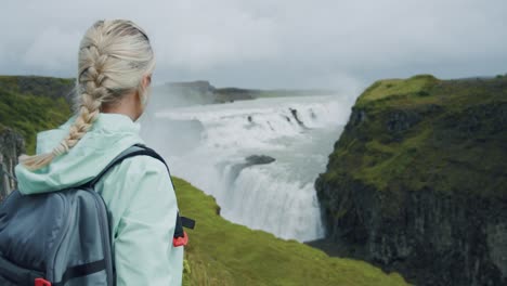 cascada gullfoss y mujer turista. famosa atracción de islandia y destino histórico en la isla del círculo dorado