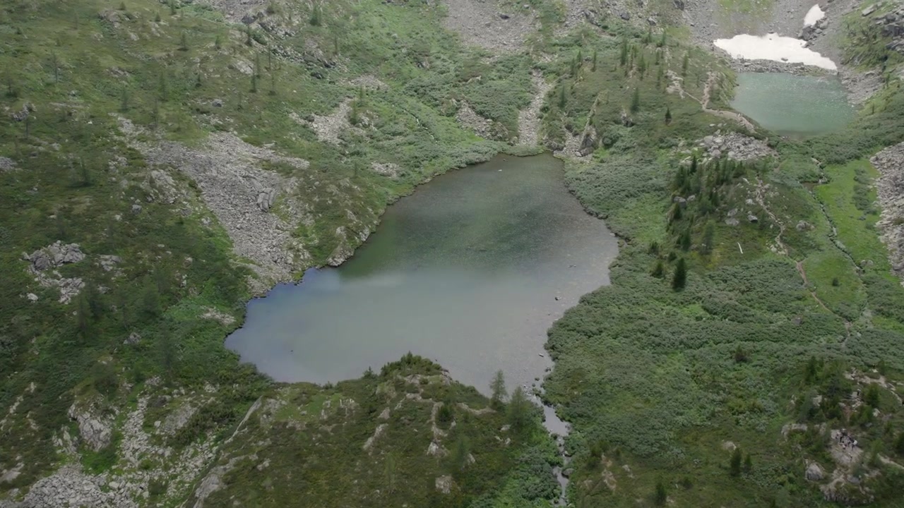 Droneopptak av Karakol-sjøene omgitt av steinete skråninger, bartrær og alpin tundra i Altajfjellene, Russland, avsidesliggende villmarkslandskap