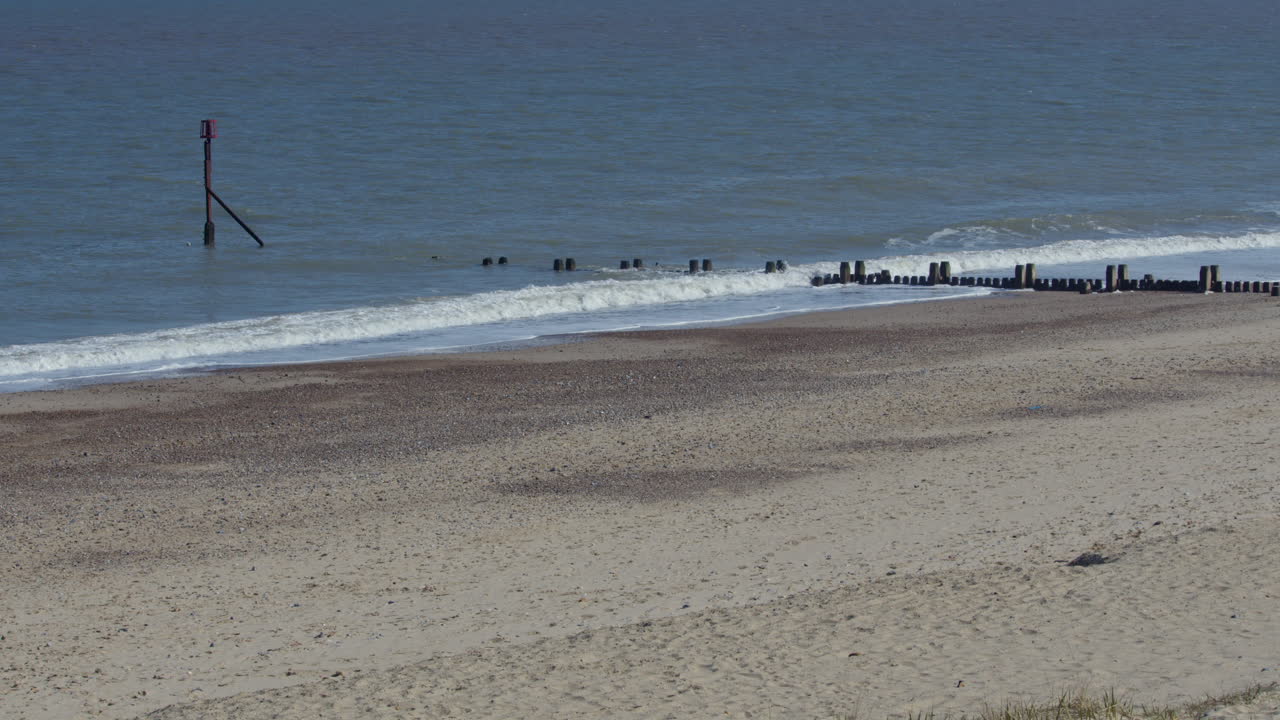 shot of the waves crashing over the sea defence groynes at Bacton beach