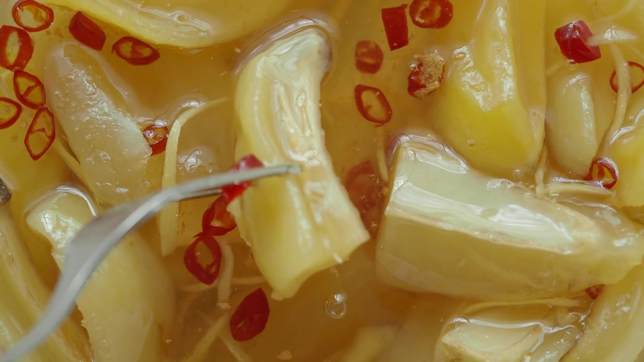 Forchetta che raccoglie germogli di bambù sottaceto con peperoncino