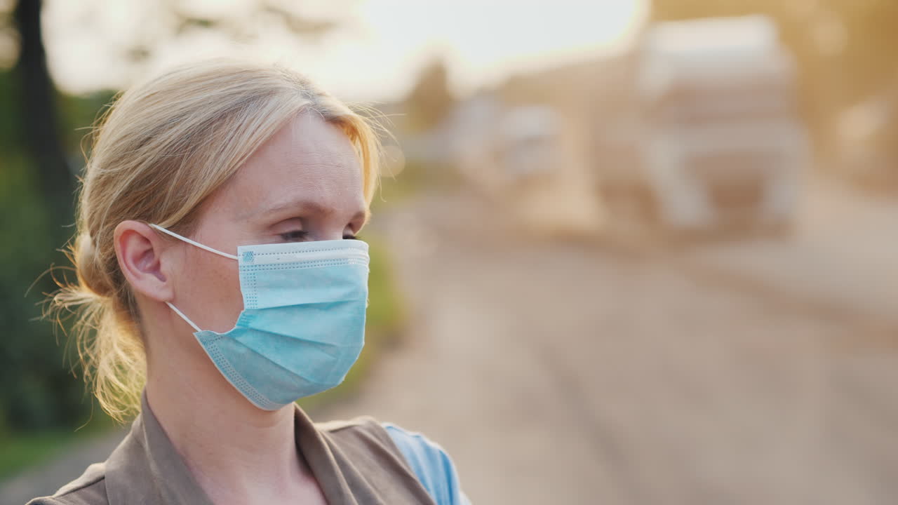 먼지가 많은 도로 생태 문제 개념에 보호 마스크를 쓴 여자