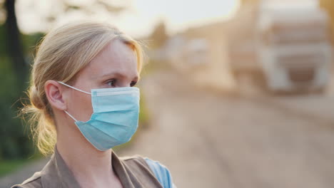 una mujer con una máscara protectora en un camino polvoriento concepto de problemas ecológicos