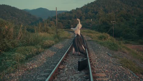 woman walking alone on train tracks