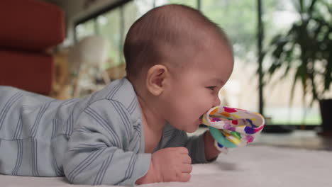 mischievous baby biting teething toys and smiling