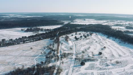 Alta-Vista-Aérea-Del-Paisaje-Cubierto-De-Nieve-Con-Bosques-Y-Carreteras