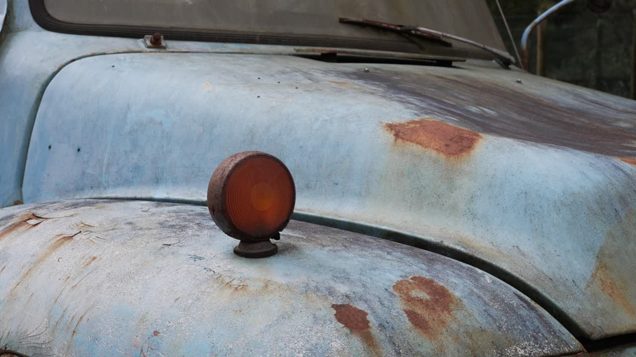 Close up of rusted signal indicator on old blue truck showing weathered paint