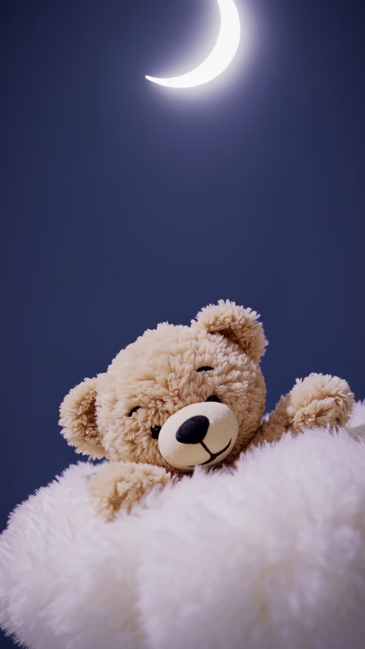 En blød bamse hviler på en blød overflade under en halvmåne