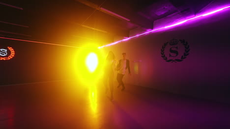 girl and boy stand in the dance studio. pair start hip hop dance at the backdrop of projector.