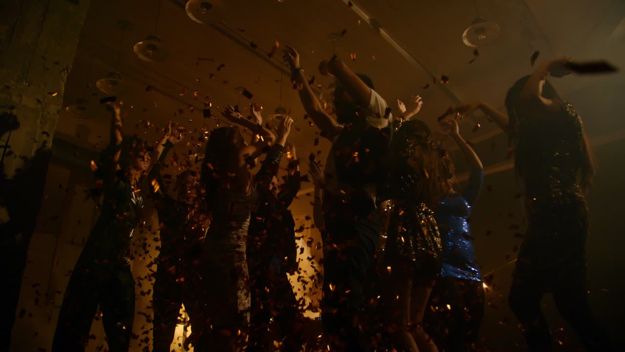 Partying People Throwing Confetti and Dancing