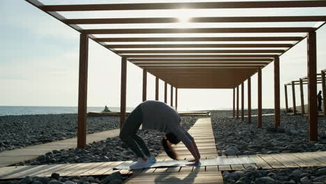 woman practicing yoga on a beach